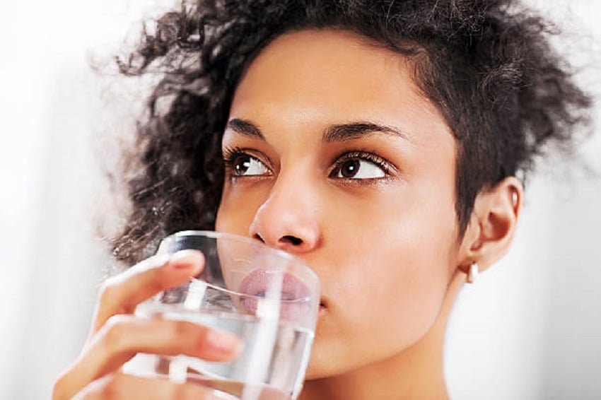 Close-up of African-American woman drinking water.