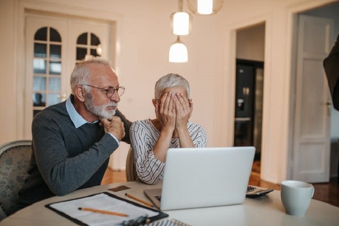 old-couple-looking-at-laptop-in-dismay