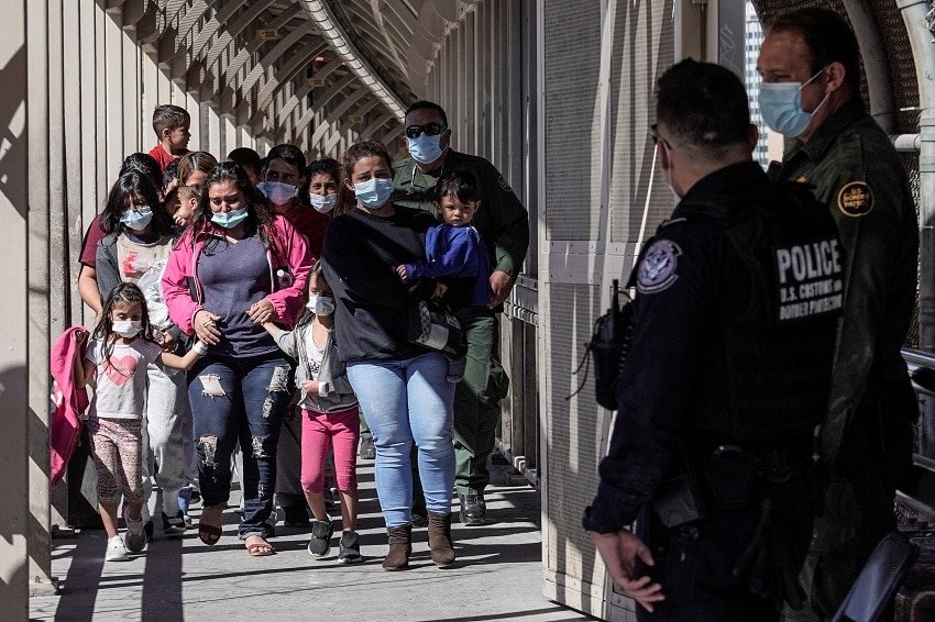Migrants from Central America that arrived in a chartered flight from Brownsville, Texas, U.S., and are expelled to Mexico cross the Paso Del Norte International bridge in Ciudad Juarez
